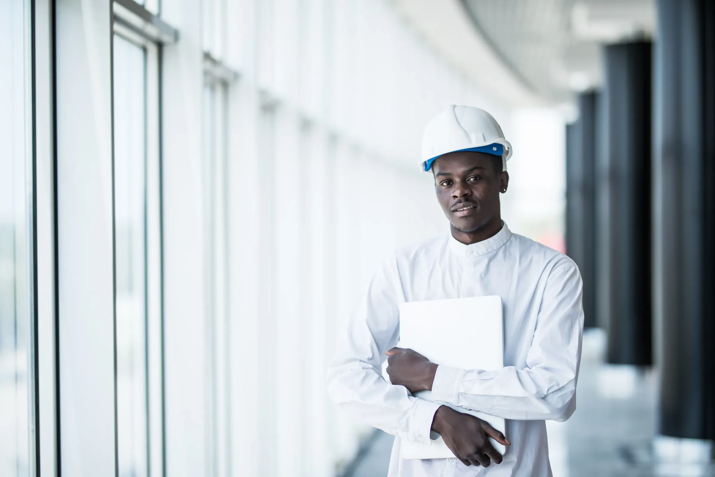 Engineer with hardhat and laptop on construction site